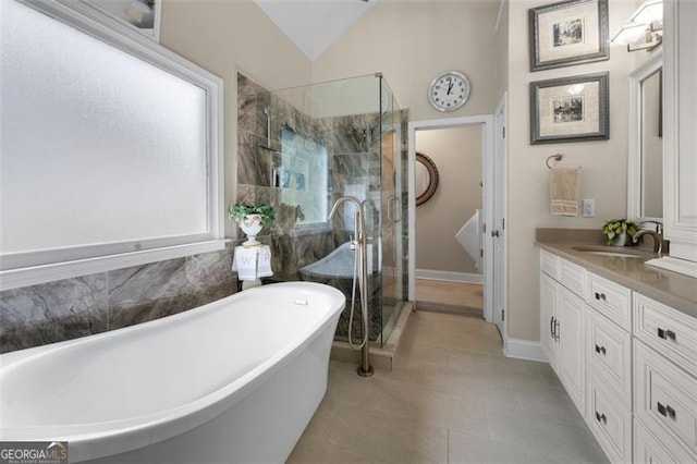 bathroom with double vanity, a shower stall, a sink, and tile patterned flooring