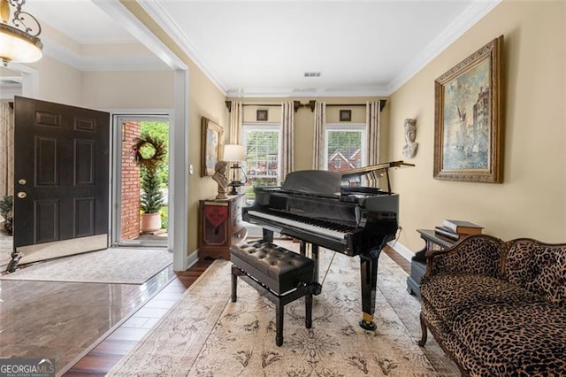 sitting room featuring crown molding, baseboards, plenty of natural light, and wood finished floors