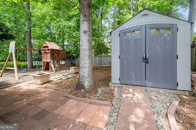 view of shed with a playground and fence