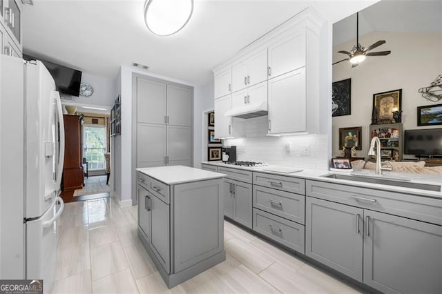 kitchen featuring a sink, light countertops, gray cabinets, and white appliances