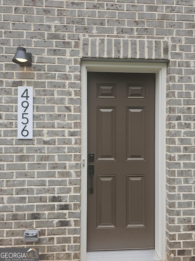 view of exterior entry with brick siding