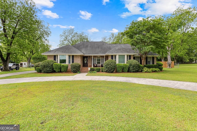 ranch-style home with curved driveway, a porch, a front lawn, and brick siding