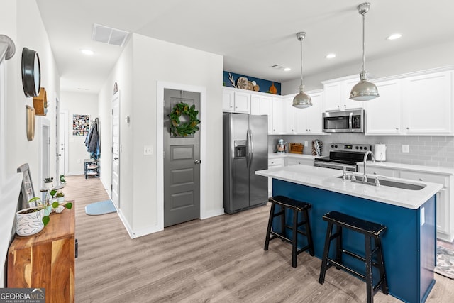 kitchen with visible vents, a sink, light wood-style flooring, and stainless steel appliances