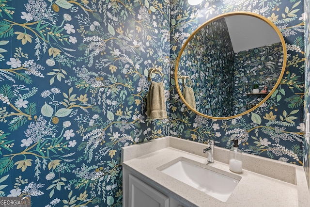 bathroom featuring vanity and wallpapered walls