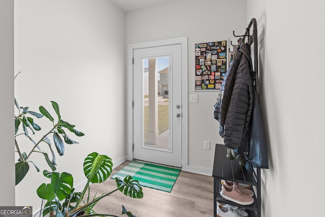 doorway to outside with baseboards and wood finished floors