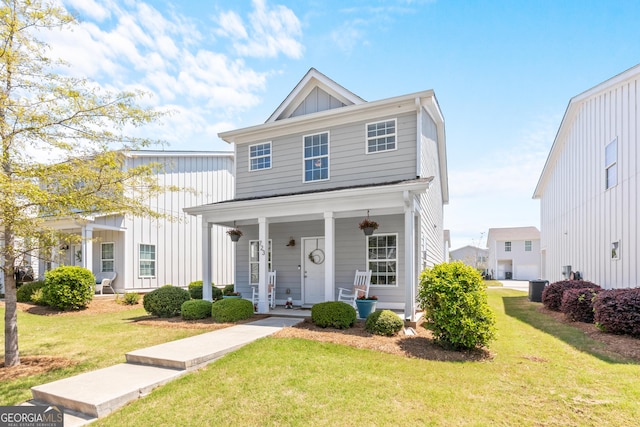 view of front of home featuring board and batten siding, covered porch, a front yard, and cooling unit