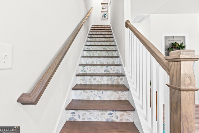 stairway featuring visible vents and wood finished floors