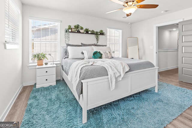 bedroom featuring multiple windows and wood finished floors