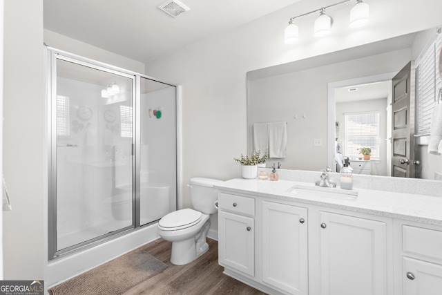 bathroom with vanity, a stall shower, wood finished floors, and visible vents