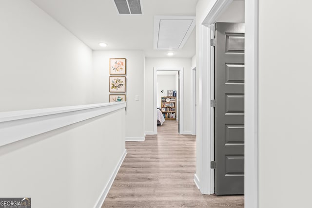 corridor with visible vents, baseboards, attic access, recessed lighting, and light wood finished floors