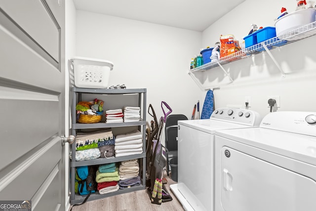 washroom featuring laundry area, washing machine and dryer, and wood finished floors