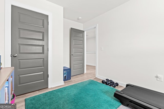 exercise area featuring baseboards and light wood-type flooring