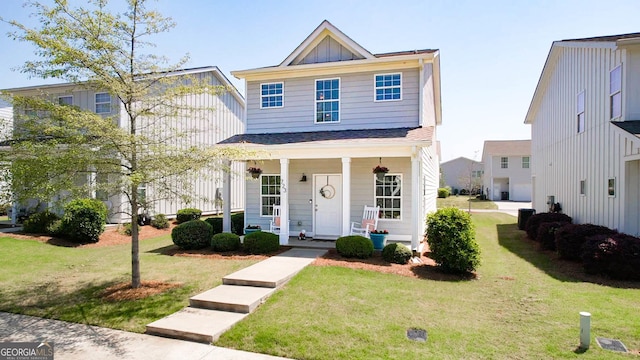 view of front of home featuring a front lawn, board and batten siding, and covered porch