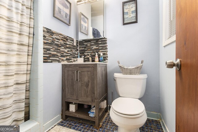 1239 Sharonton Dr, Stone Mountain, GA 30083 - bathroom with toilet, vanity, tile patterned floors, tasteful backsplash, and baseboards