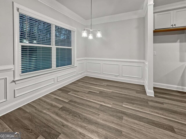 5291 Tuscany Dr, Douglasville, GA 30135 - unfurnished dining area with crown molding, a decorative wall, dark wood-style floors, and a wainscoted wall