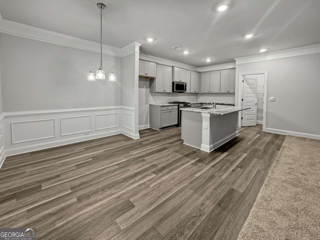 5291 Tuscany Dr, Douglasville, GA 30135 - kitchen with crown molding, appliances with stainless steel finishes, a sink, a kitchen island with sink, and dark wood-style floors
