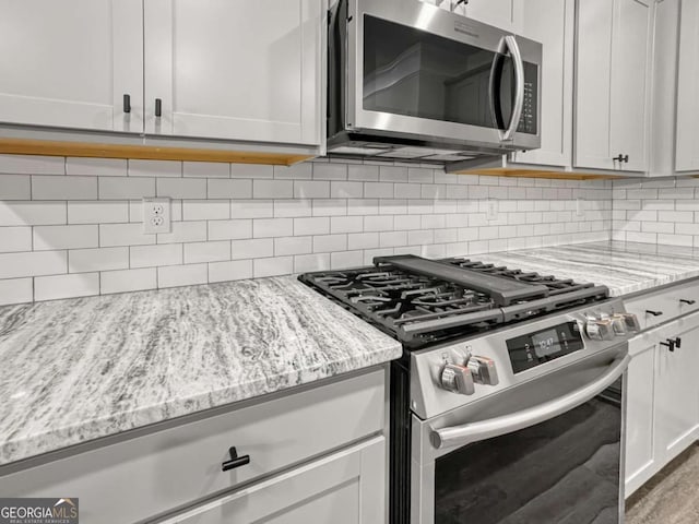 5291 Tuscany Dr, Douglasville, GA 30135 - kitchen featuring light stone counters, appliances with stainless steel finishes, and tasteful backsplash