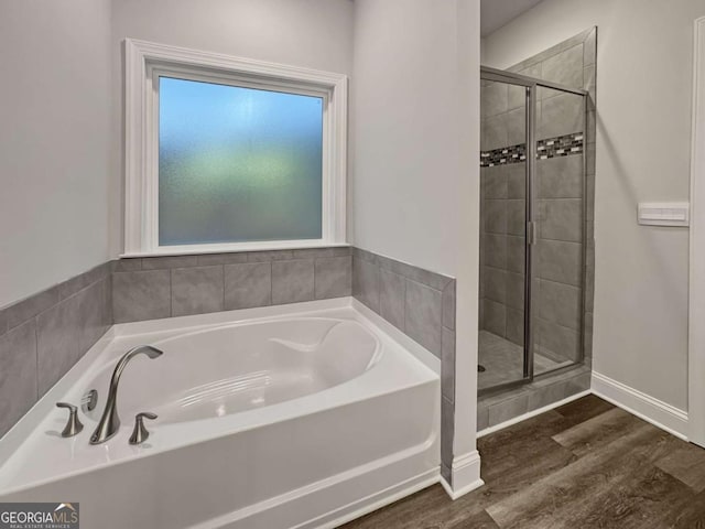 5291 Tuscany Dr, Douglasville, GA 30135 - bathroom featuring wood finished floors, a bath, and a stall shower