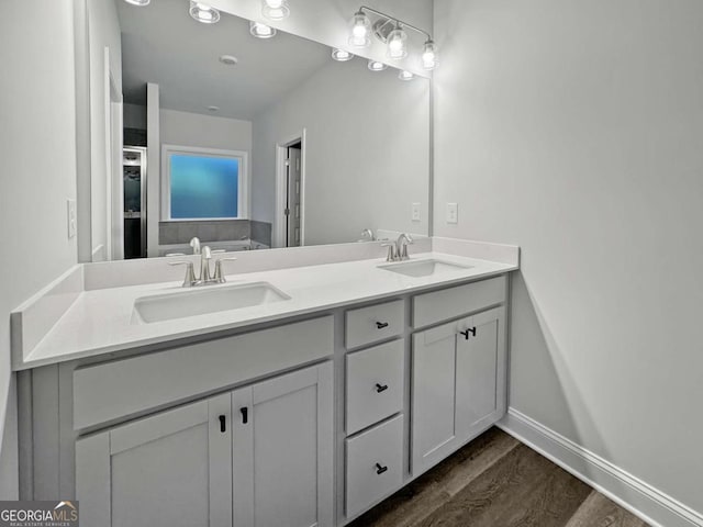 5291 Tuscany Dr, Douglasville, GA 30135 - full bathroom featuring double vanity, baseboards, a sink, and wood finished floors