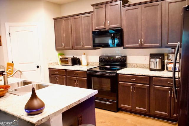584 Amaranth Trl, Hoschton, GA 30548 - kitchen featuring black appliances, a sink, light wood-style flooring, backsplash, and dark brown cabinetry