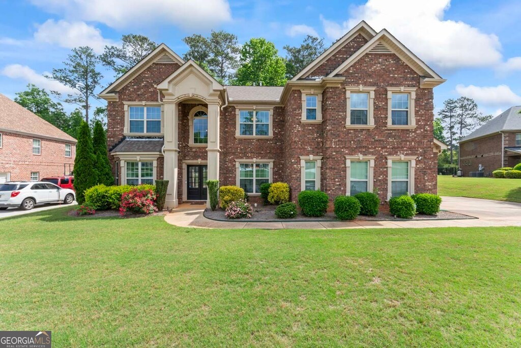 305 Spooner Dr, Mcdonough, GA 30252 - view of front facade with brick siding and a front lawn