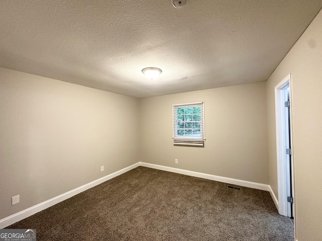 empty room with dark carpet, baseboards, and visible vents