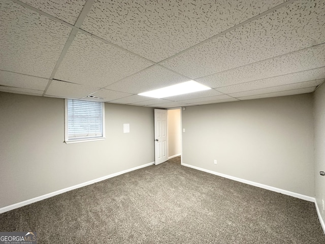 basement with carpet floors, baseboards, and a drop ceiling