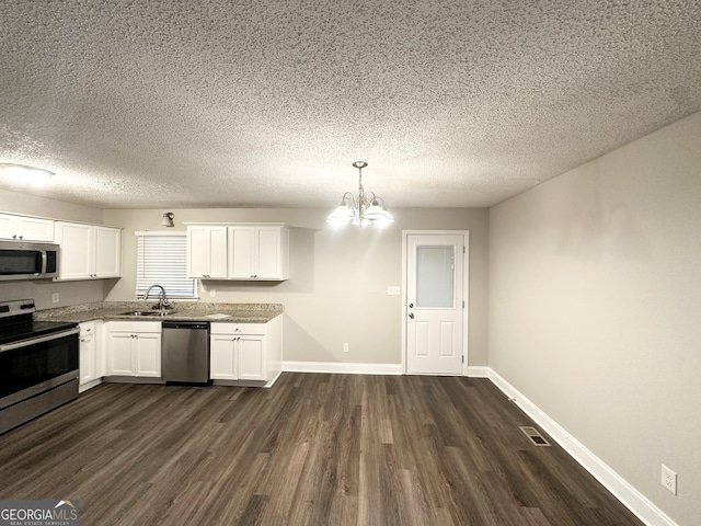 kitchen featuring white cabinets, dark wood-style flooring, an inviting chandelier, a textured ceiling, and stainless steel appliances