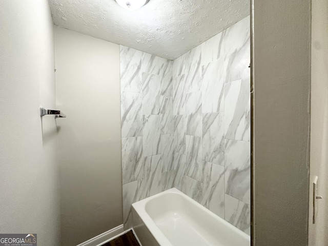 full bathroom featuring shower / bathtub combination and a textured ceiling