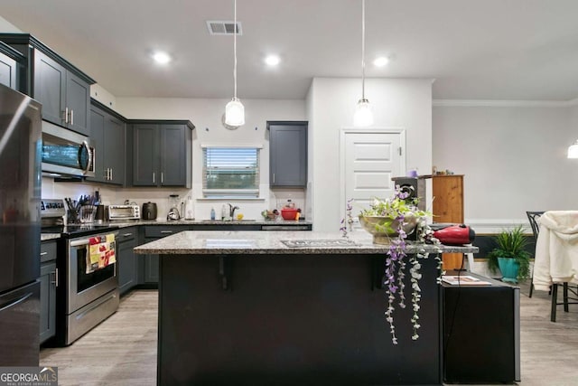 kitchen with light stone countertops, stainless steel appliances, light wood-type flooring, and visible vents