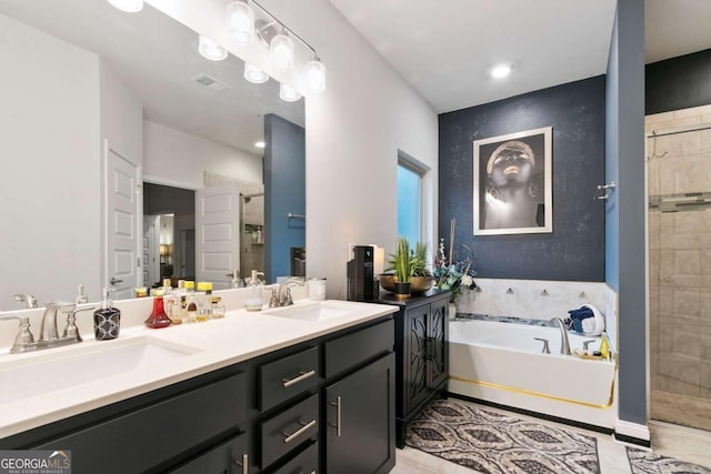 bathroom featuring visible vents, a shower stall, a sink, and a garden tub