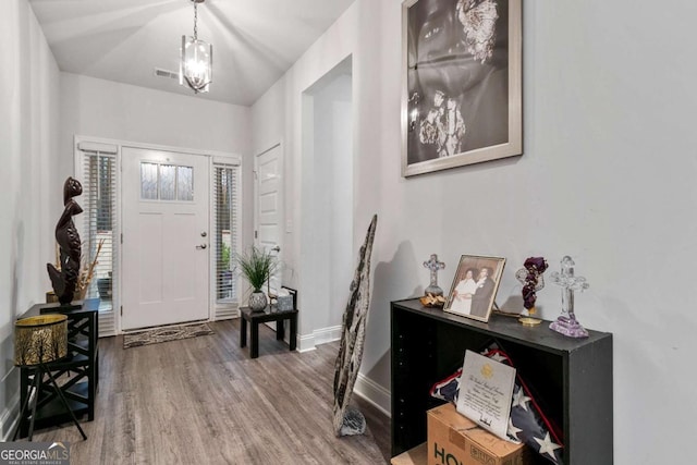 entrance foyer featuring baseboards, wood finished floors, and visible vents