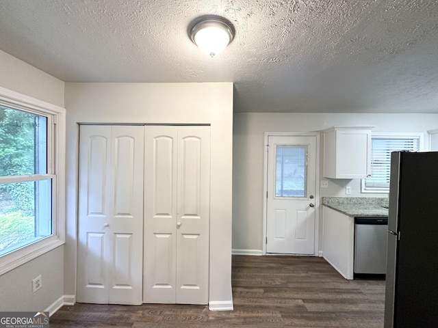 2930 Waters Rd, Atlanta, GA 30354 - kitchen featuring dark wood-style flooring, a textured ceiling, stainless steel appliances, white cabinetry, and a healthy amount of sunlight