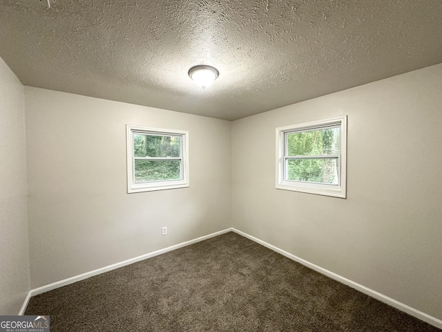 2930 Waters Rd, Atlanta, GA 30354 - unfurnished room with plenty of natural light, a textured ceiling, baseboards, and dark carpet