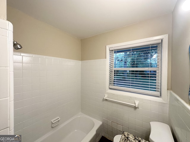 full bath featuring wainscoting, toilet, tile walls, walk in shower, and a bath