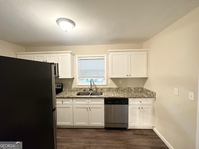 kitchen with appliances with stainless steel finishes, light stone counters, a sink, white cabinetry, and dark wood-style floors