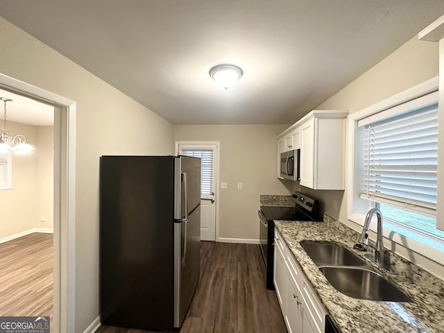 kitchen with dark wood-style flooring, a sink, baseboards, stainless steel appliances, and white cabinetry