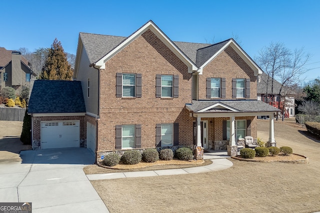 2225 Independence Ln, Buford, GA 30519 - view of front of home with brick siding, covered porch, a garage, concrete driveway, and a shingled roof