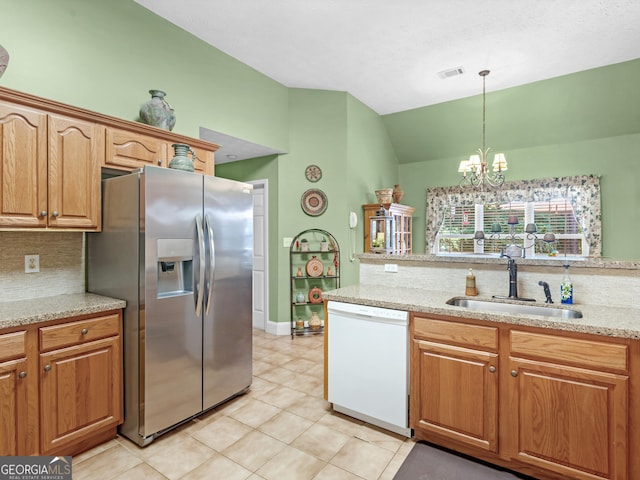 kitchen featuring decorative backsplash, white dishwasher, a sink, lofted ceiling, and stainless steel fridge
