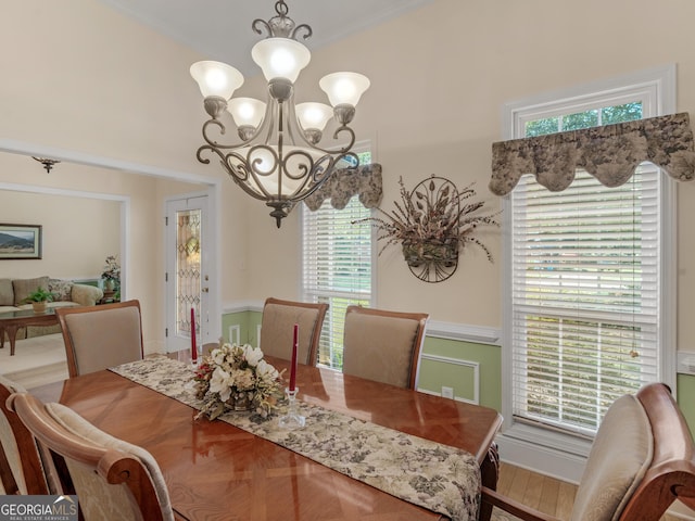 dining area with crown molding, an inviting chandelier, and a wealth of natural light