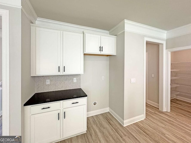 5321 Tuscany Dr, Douglasville, GA 30135 - kitchen featuring crown molding, dark countertops, light wood-style floors, white cabinetry, and decorative backsplash