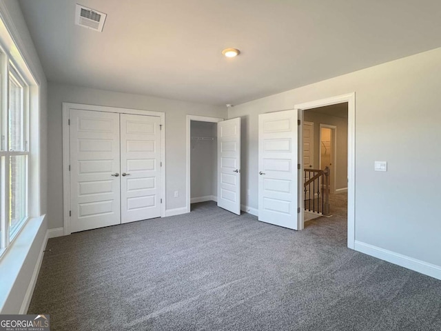 5321 Tuscany Dr, Douglasville, GA 30135 - unfurnished bedroom featuring visible vents, baseboards, dark carpet, and two closets