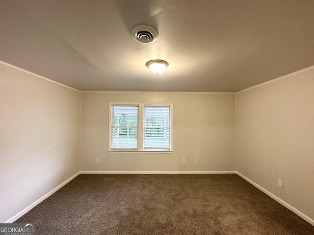 empty room featuring dark carpet, ornamental molding, baseboards, and visible vents