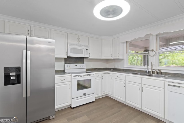 kitchen featuring light wood-type flooring, a sink, white cabinets, ornamental molding, and white appliances