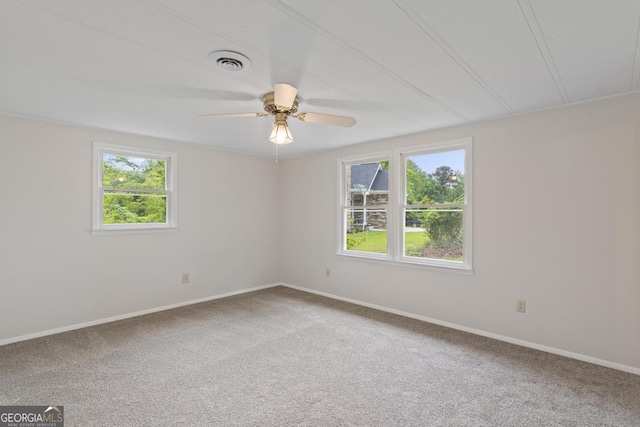 carpeted spare room with a ceiling fan, baseboards, and visible vents