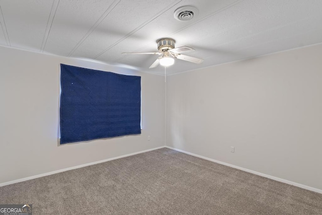 empty room featuring carpet floors, baseboards, ceiling fan, and visible vents