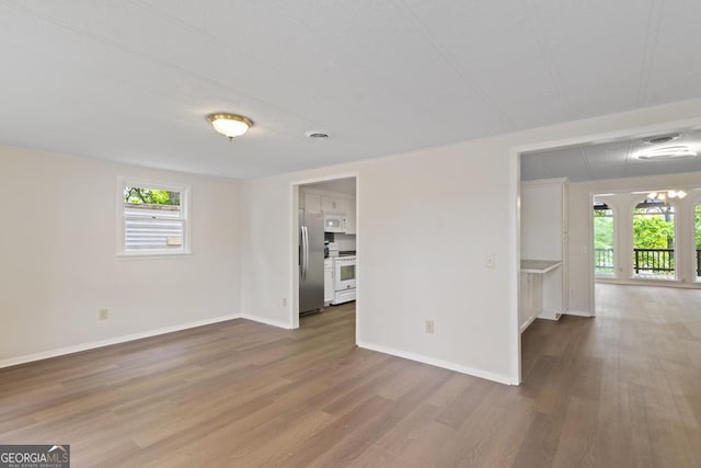 unfurnished living room featuring baseboards and wood finished floors