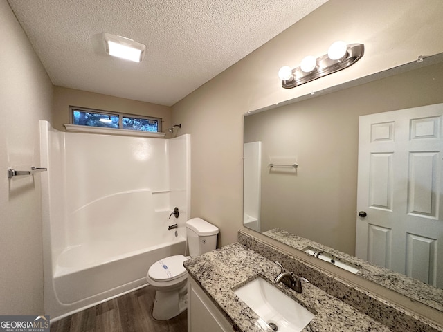 263 Coral Cir, Mcdonough, GA 30253 - full bath featuring a textured ceiling, wood finished floors, vanity, toilet, and tub / shower combination