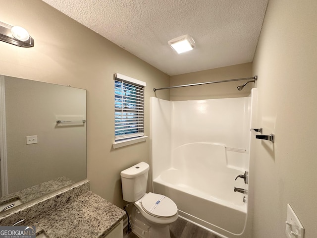 263 Coral Cir, Mcdonough, GA 30253 - bathroom with vanity, wood finished floors, bathing tub / shower combination, toilet, and a textured ceiling