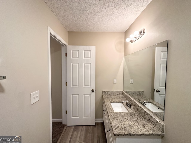 263 Coral Cir, Mcdonough, GA 30253 - bathroom with a textured ceiling, baseboards, vanity, and wood finished floors